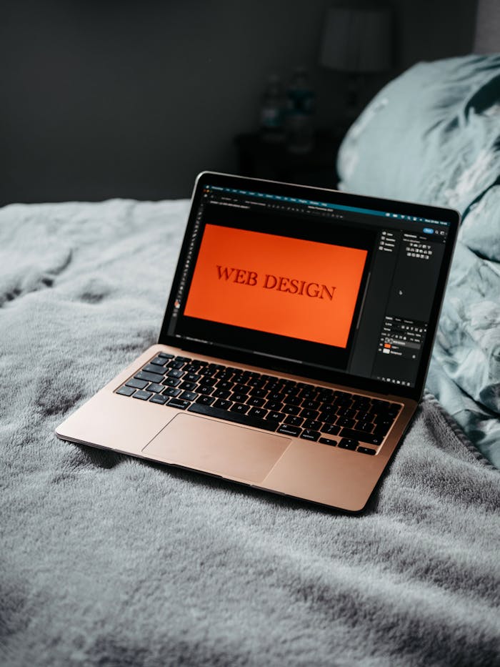 about-01 A laptop on a bed showing web design software, creating a cozy workspace.
